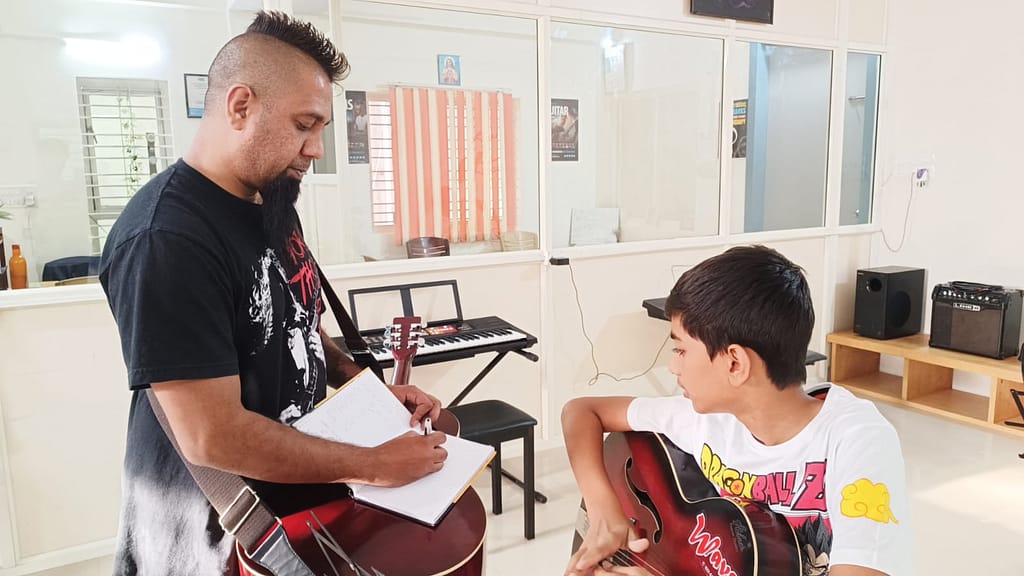 Eric Rodrigues teaching guitar to a student at The First Chord Music & Art School.