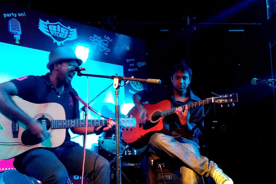 Eric Vivian Rodrigues performing guitar with a live band.
